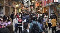 Pelancong asal China berjalan-jalan di daerah kantong China, Makau, 17 Januari 2023. Ledakan pariwisata China yang diharapkan selama liburan Tahun Baru Imlek minggu depan tampaknya akan lebih cepat terjadi. (Peter PARKS/AFP)