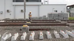 Pekerja melintasi rel di area proyek  pembangunan Stasiun Commuter Line Cikarang, Jawa Barat, Selasa (12/4). Proyek ini ditargetkan selesai dan bisa dioperasikan pada 2018. (Liputan6.com/Angga Yuniar)