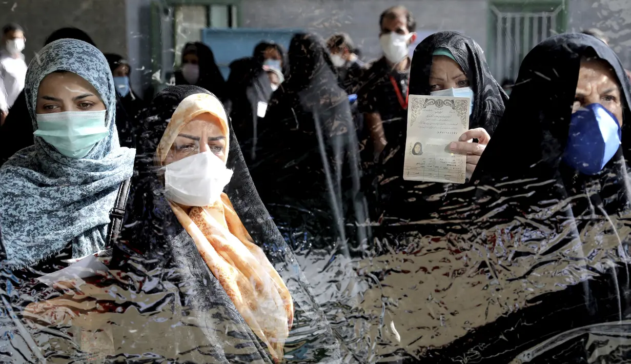 Para pemilih mendaftar untuk memberikan suara mereka selama pemilihan presiden di sebuah tempat pemungutan suara di Teheran, Iran, Jumat (18/6/2021). Warga Iran mulai memberikan suaranya dalam pemilihan presiden. (AP Photo/Ebrahim Noroozi)