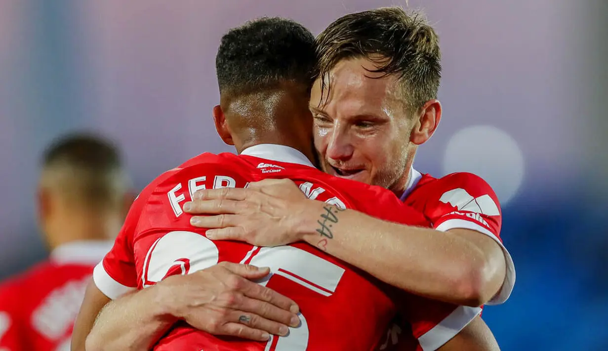 Pemain Sevilla, Fernando, dipeluk oleh Ivan Rakitic, usai mencetak gol ke gawang Real Madrid pada laga Liga Spanyol di Stadion Alfredo di Stefano, Minggu (10/5/2021). Kedua tim bermain imbang 2-2. (AP/Manu Fernandez)