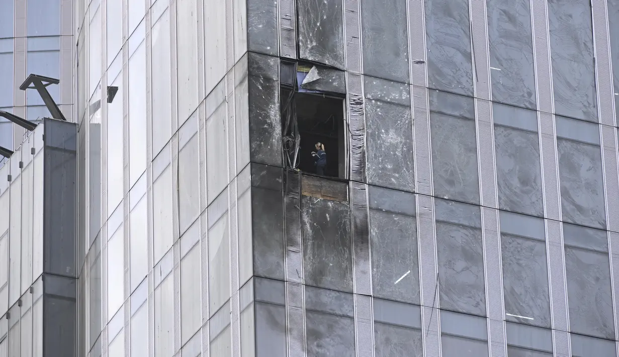 Seorang penyelidik memeriksa gedung pencakar langit yang rusak di kawasan bisnis Kota Moskow setelah laporan serangan pesawat tak berawak atau drone di Moskow, Rusia, Rabu (23/8/2023). (AP Photo)