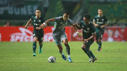 Pemain Persebaya Surabaya, Koko Ari Araya (kiri) berebut bola dengan pemain Persikabo 1973, Munadi dalam laga pekan pertama BRI Liga 1 2022/2023 antara Persikabo 1973 melawan Persebaya Surabaya di Stadion Pakansari, Bogor, Senin (25/7/2022) malam WIB. (Bola.com/M Iqbal Ichsan)