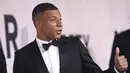 <p>Penyerang PSG, Kylian Mbappe berpose untuk fotografer setibanya menghadiri AmfAR Cinema Against AIDS Benefit selama festival film internasional Cannes ke-75 di Hotel du Cap-Eden-Roc, Cap d'Antibes, Prancis selatan, Kamis (26/5/2022). Mbappe tampil mengenakan jas hitam berdasi kupu-kupu. (AP Photo/Vianney Le Caer)</p>