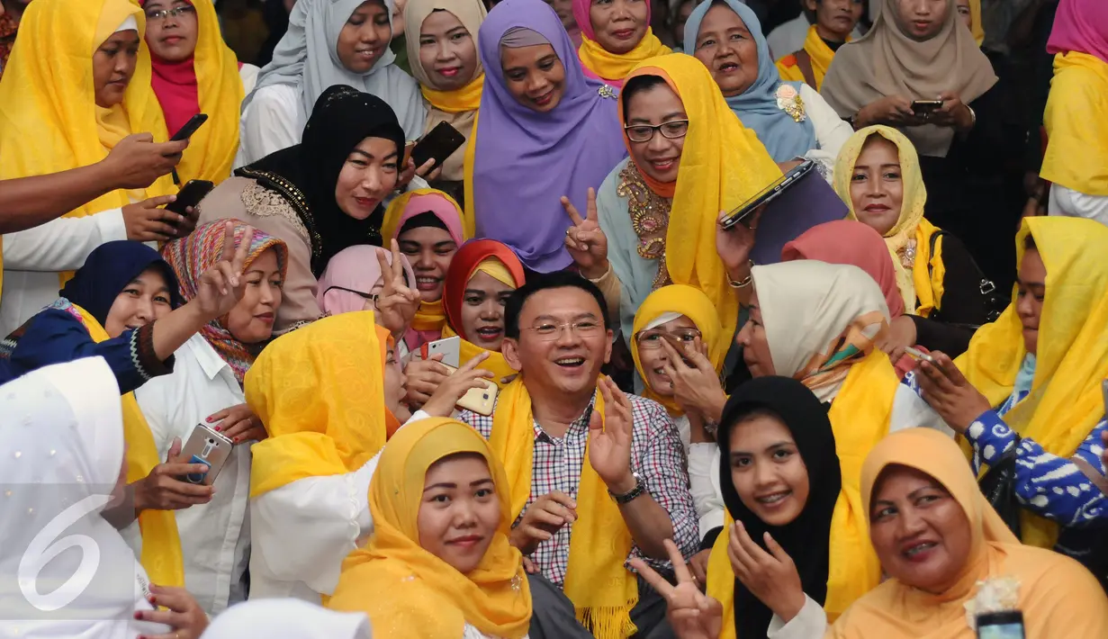 Cagub DKI Jakarta Basuki Tjahaja Purnama (tengah) berfoto bersama warga saat menghadiri ulang tahun Ketua Dewan Pakar Golkar, Agung Laksono di Jakarta, Minggu (26/3). Ketum Golkar Setya Novanto juga terlihat hadir. (Liputan6.com/Helmi Fithriansyah)