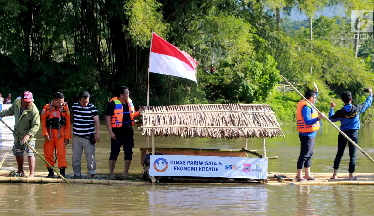 Mantan Menteri Perdagangan Rahmat Gobel saat menyusuri sungai Bone mengunakan rakit tradisional di Gorontalo, Sabtu (23/3). Seluruh SKPD Kabupaten Bonebol menyediakan rakit untuk dinaiki bagi siapa yang ingin menikmati dan menyeusuri bantaran sungai bone. (Liputan6.com/Arfandi Ibrahim)