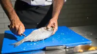 Ilustrasi membersihkan sisik ikan. (Foto oleh Kampus Production: https://www.pexels.com/id-id/foto/tangan-koki-dapur-talenan-8629093/)