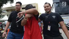 Tersangka berinisial MIK penyebar hoax surat suara tercoblos yang berprofesi sebagai guru di Cilegon digiring petugas di Polda Metro Jaya, Jakarta, Jumat (11/1). Screenshot posting-an di Twitter MIK menjadi barang bukti polisi. (Merdeka.com/Imam Buhori)