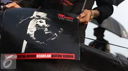 Aktivis memperlihatkan poster Munir saat aksi Kamisan di Jakarta, Kamis (8/9). Dalam aksinya mereka kembali meminta penyelesaian pelanggaran HAM, khususnya kasus pembunuhan Munir yang telah 12 tahun berlalu. (Liputan6.com/Immanuel Antonius)