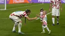 Kapten Kroasia, Luka Modric bermain dengan anak Mateo Kovacic, Ivan saat timnya berhasil menyabet peringkat ketiga Piala Dunia 2022 setelah mengalahkan Maroko dengan skor 2-1 pada laga yang berlangsung di Khalifa International Stadium, Doha, Qatar, Sabtu (17/12/2022). (AP Photo/Frank Augstein)