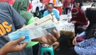 Warga menunjukkan STNK yang baru diperpanjang di gerai Samsat Keliling Car Free Day, Jakarta, Minggu (21/10). Layanan pembayaran pajak Surat Tanda Nomor Kendaraan (STNK) bisa dilakukan tanpa membawa salinan atau BPKB. (Liputan6.com/Angga Yuniar)