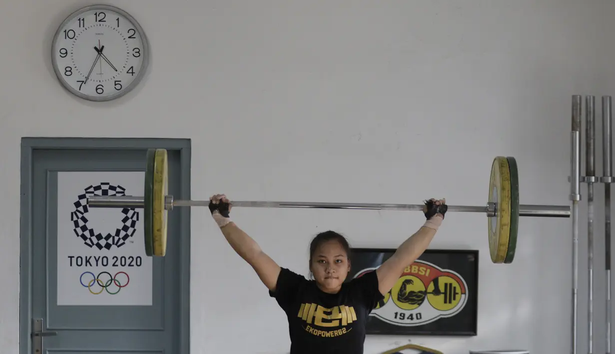 Atlet Pelatnas angkat besi, Juliana Klarisa, saat latihan di Wisma Kwini, Jakarta, Senin (30/9). Latihan tersebut dalam rangka persiapan jelang Sea Games 2019 di Filipina. (Bola.com/M Iqbal Ichsan)