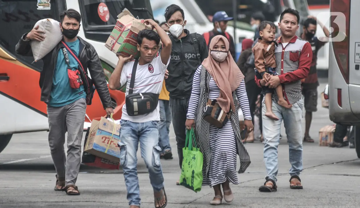 Pemudik membawa barang bawaan mereka seusai turun dari bus antarkota antarprovinsi (AKAP) di Terminal Kampung Rambutan, Jakarta, Minggu (23/5/2021). Kementerian Perhubungan memprediksi puncak arus balik Lebaran 2021 terjadi pada hari ini usai larangan mudik berakhir. (merdeka.com/Iqbal S Nugroho)