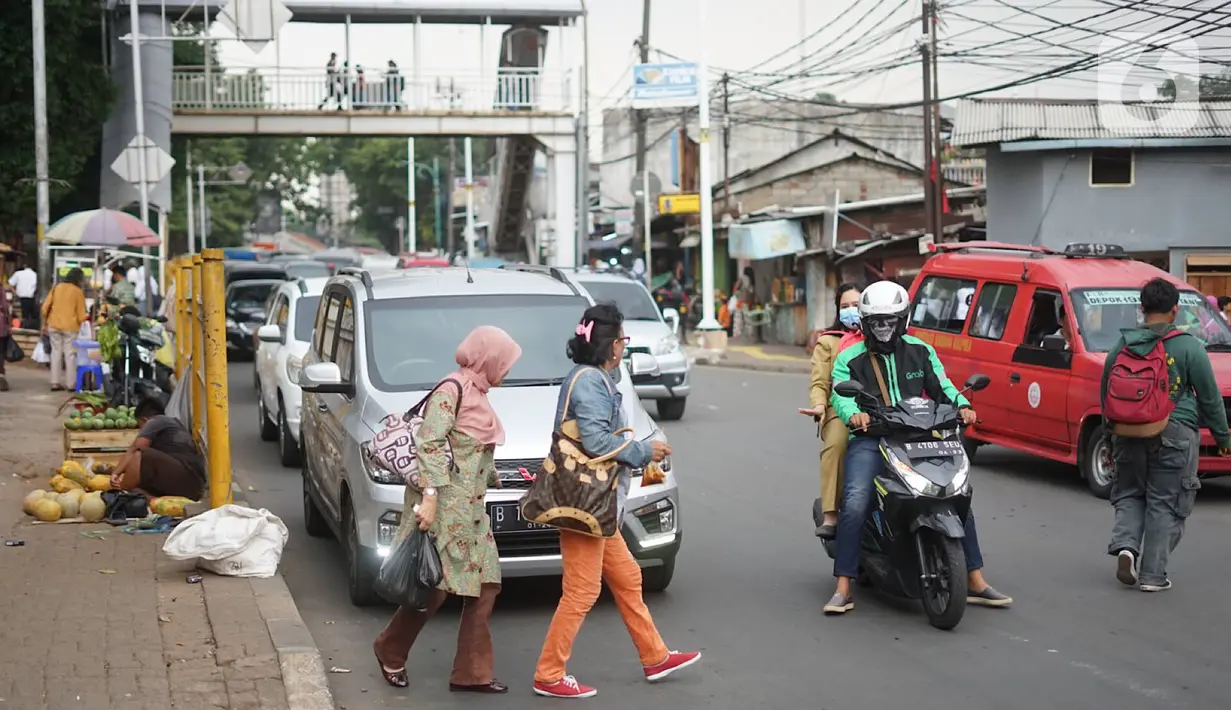 Pejalan kaki menyeberangi jalan di depan Stasiun Lenteng Agung, Jakarta, Senin (4/11/2019). Meski telah tersedia JPO, sebagian pejalan kaki lebih memilih untuk menyeberang sembarangan sehingga mengganggu arus lalu lintas serta berpotensi menimbulkan kecelakaan. (Liputan6.com/Immanuel Antonius)