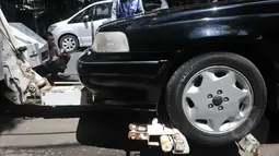 Alat derek telah terpasang pada sebuah mobil sedan hitam di kawasan Cikini, Jakarta, Selasa (28/4/2015). (Liputan6.com/JohanTallo)