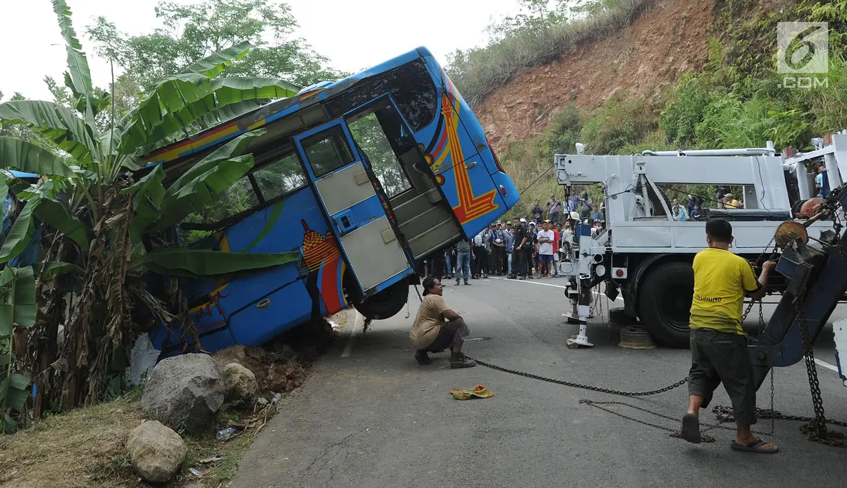 Upaya evakuasi bangkai bus maut Jakarta Wisata Transport yang masuk jurang di jalur alternatif Cikidang, Sukabumi, Jawa Barat, Minggu (9/9). Bus bernopol B 7025 SGA ini terjun ke sebuah jurang sedalam sekitar 30 meter. (Merdeka.com/Arie Basuki)