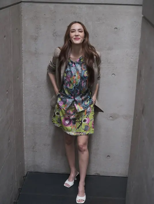 Tampil semarak dengan dress bermotif ceria? Tambahkan blazer berwarna netral untuk meredamnya (Foto: Instagram @cathysharon)