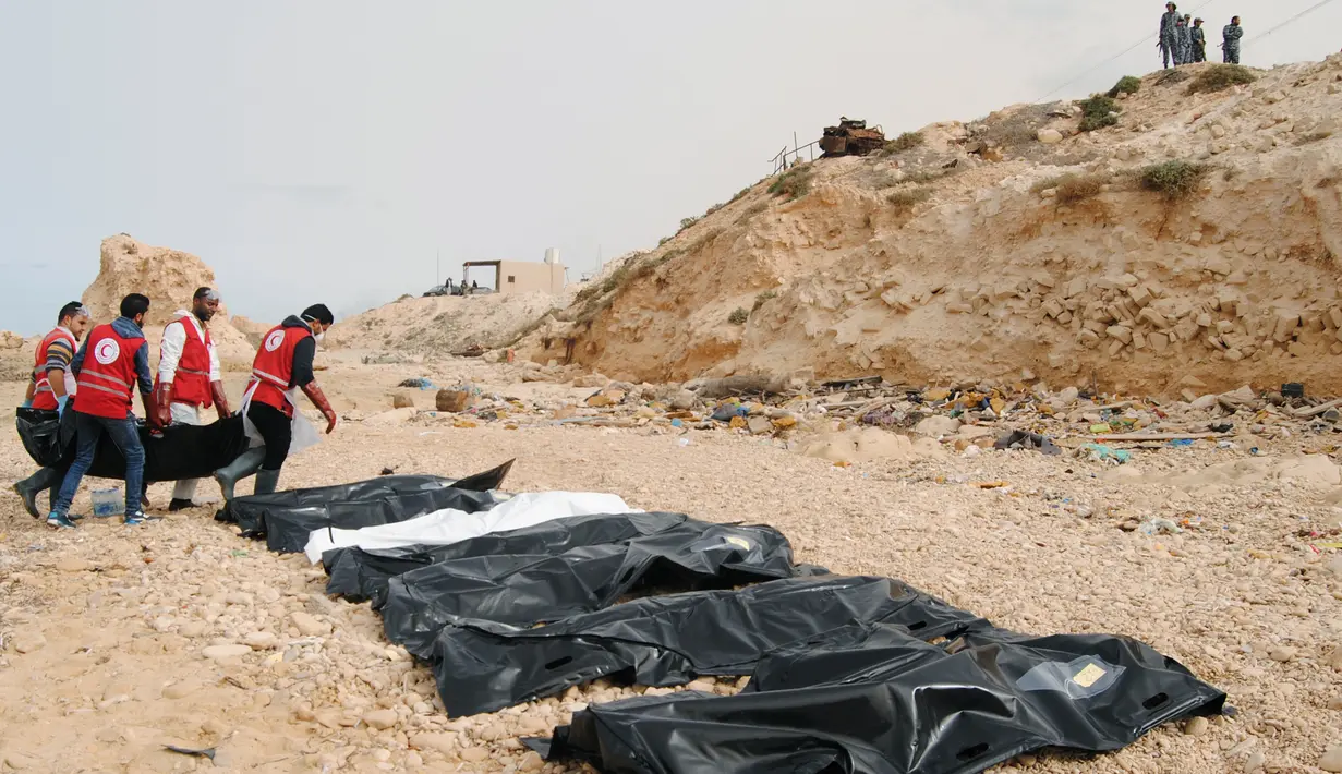 Petugas Bulan Sabit Merah Libya mengumpulkan jenazah para imigran yang ditemukan terdampar di pantai utara Libya, Selasa (21/2). Setidaknya terdapat 74 jenazah yang terdampar di pantai yang terhubung dengan Laut Mediterania tersebut. (MOHANED KREMA/AFP)