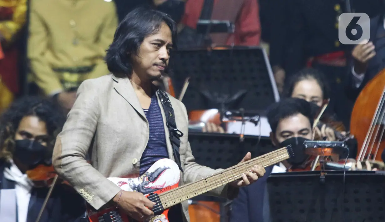 Gitaris Dewa Budjana saat Konser Kebangsaan, Simfoni Insan Perhubungan, Bangkit Maju Bersama di Jakarta, Sabtu (6/8/2022). Konser Kebangsaan tersebut dalam rangka memeriahkan HUT RI ke-77 dan menyambut Hari Perhubungan Nasional (Harhubnas) ke-52, Kementerian Perhubungan. (Liputan6.com/Herman Zakharia)