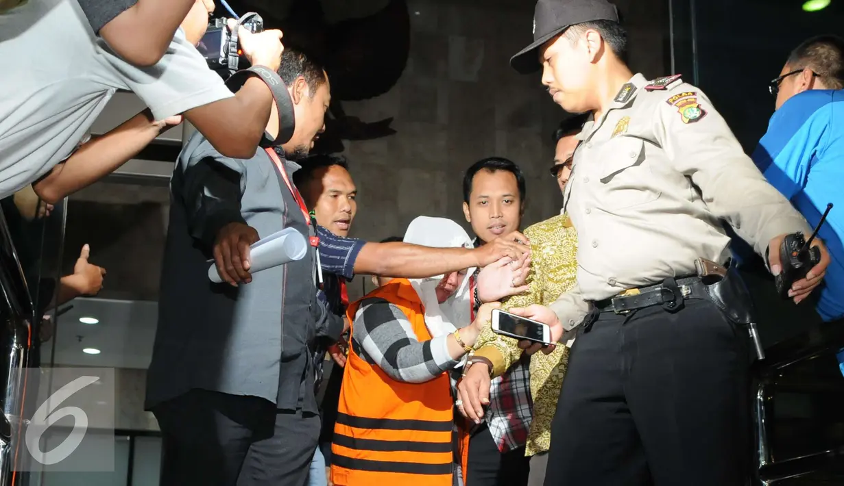 Sri Hartini dikawal petugas polisi meninggalkan gedui KPK usai menjalani pemeriksaan, Jakarta, Sabtu (31/12). KPK menetapkan Bupati Klaten Sri Hartini dan Suramlan terkait dugaan kasus suap pengaturan jabatan. (Liputan6.com/Helmi Afandi)