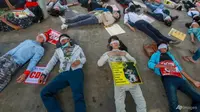 Demonstran, dengan mata tertutup, berbaring di jalan untuk memprotes kudeta militer di Yangon, Myanmar, pada 16 Februari 2021. (Foto: AP)