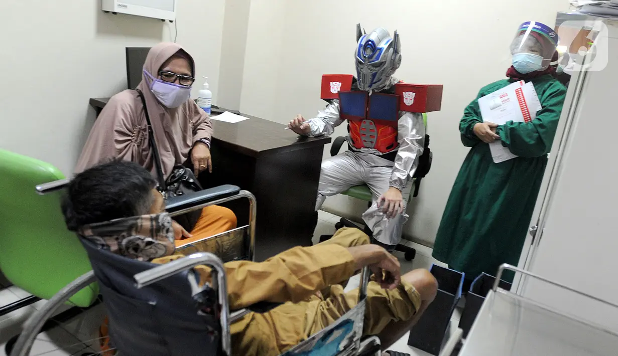 Dokter Rollando Erric Manibuy SpOT mengenakan alat pelindung diri (APD) ala transformer saat melayani pasiennya di RS Vania, Bogor, Jawa Barat, Jumat (22/5/2020). Penggunaan APD unik sejak merebaknya COVID-19 tersebut agar pasien tetap optimis meski sedang dalam pandemi. (merdeka.com/Arie Basuki)