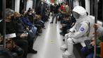 Seorang pria berpakaian astronaut naik metro sebagai bagian dari kampanye untuk mempromosikan Pameran Luar Angkasa NASA di Istanbul, Turki, pada 4 Desember 2021. Pameran ini akan menampilkan modul khusus dari luar angkasa dan puluhan instrumen berteknologi tinggi. (AP Photo/Emrah Gurel)