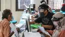 Petugas menggunakan face shield saat melayani masyarakat Dinas Kependudukan Kecamatan Pamulang, Tangerang Selatan, Jumat (29/5/2020).  Penggunaan Face Shield tersebut sebagai salah satu upaya untuk melindungi diri dalam penyebaran COVID-19. (Liputan6.com/Faizal Fanani)