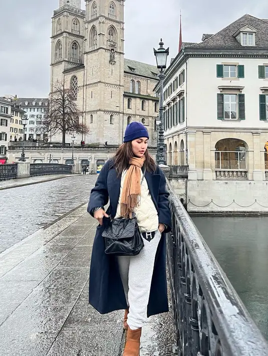 Di Swiss, Ayu Ting Ting memadukan coat winter dengan sweater dan syal nuansa coklat. [@ayutingting92].