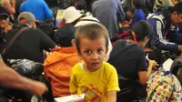Seorang anak saat menunggu di Pelabuhan Tanjung Emas, Semarang , Senin (25/1). Total ada 42 orang eks Gafatar yang sakit, terinci 28 dewasa dan 14 anak-anak. mengalami menderita dehidrasi, demam, dan  muntah.  (Liputan6.com/Gholib)