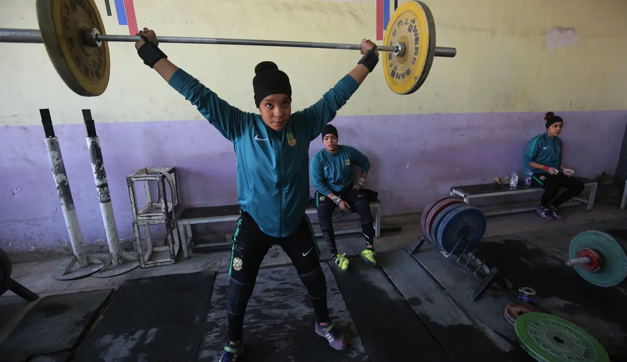 Atlet angkat besi wanita Irak Hadeel Salem Al-Saedi berlatih di sebuah klub di Kota Sadr, sebelah timur Baghdad, Irak (18/1). Para atlet wanita ini berlatih dengan giat tiap harinya. (AFP Photo/Ahmad Al-Rubaye)