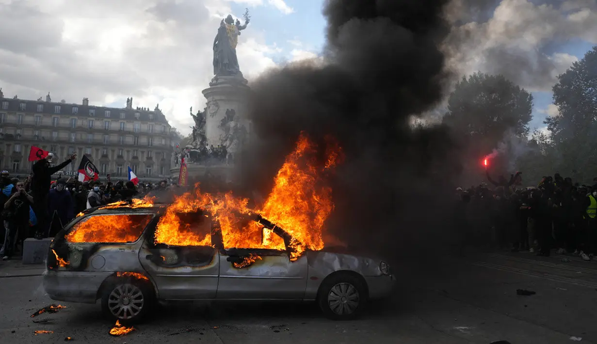 Sebuah mobil terbakar di Lapangan République saat aksi demonstrasi menentang kenaikan biaya hidup dan menyuarakan keluhan mahasiswa di Paris, Prancis, Sabtu (17/10/2026). (AP Photo/Thibault Camus)