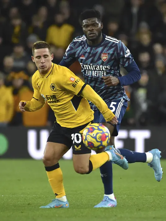 Pemain Wolverhampton Wanderers, Daniel Podence membawa bola dari kawalan pemain Arsenal, Thomas Partey selama pertandingan lanjutan Liga Inggris di stadion Molineux di Wolverhampton, Inggris, Jumat (11/2/2022). Arsenal menang tipis atas Wolverhampton Wande 1-0. (AP Photo/Rui Vieira)