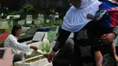 Para peziarah membawa aneka bunga lainnya untuk ditaburkan di atas makam TPU Karet Bivak, Jakarta, Senin (28/7/14). (Liputan6.com/Johan Tallo)