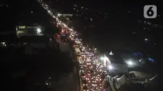 Foto udara saat pemudik melintas di posko penyekatan mudik di Kedungwaringin, Kabupaten Bekasi, Jawa Barat, Minggu (9/5/2021). H-3 jelang Idul Fitri petugas gabungan TNI, Polri, Dishub dan Satpol PP memperketat penjagaan pemudik di perbatasan Kabupaten Bekasi-Karawang. (Liputan6.com/Herman Zakharia)