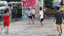 Sejumlah remaja berebut bola saat bermain di kolong rel kereta kawasan Juanda, Jakarta, Jumat (27/5). Tidak tersedianya ruang terbuka menyebabkan lahan tersebut dijadikan tempat bersosialisasi bagi warga. (Liputan6.com/Immanuel Antonius)