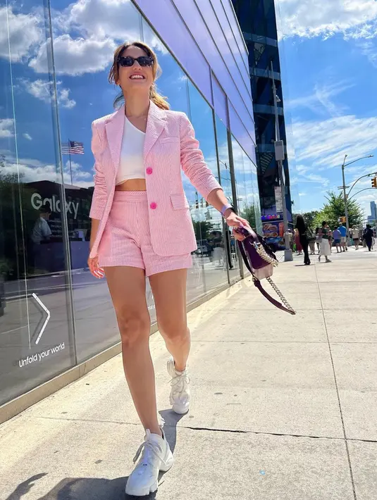 Gaya menarik Pevita Pearce liburan keluar negeri pakai blazer. Ia memadukan setelan blazer pink dengan celana pendeknya, dikombinasikan dengan tank top dan sneakers putih. [Foto: Instagram/pevpearce]