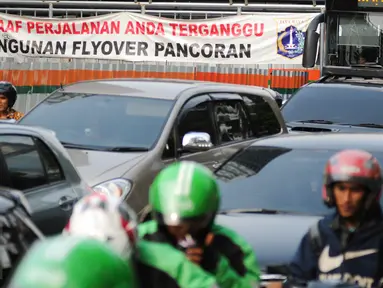 Sejumlah kendaraan melintas di sisi pembangunan flyover Pancoran, Jakarta, Selasa (11/4). Pembangunan flyover Pancoran bertujuan untuk mengurai kemacetan dari arah Cawang menuju Semanggi. (Liputan6.com/Yoppy Renato)