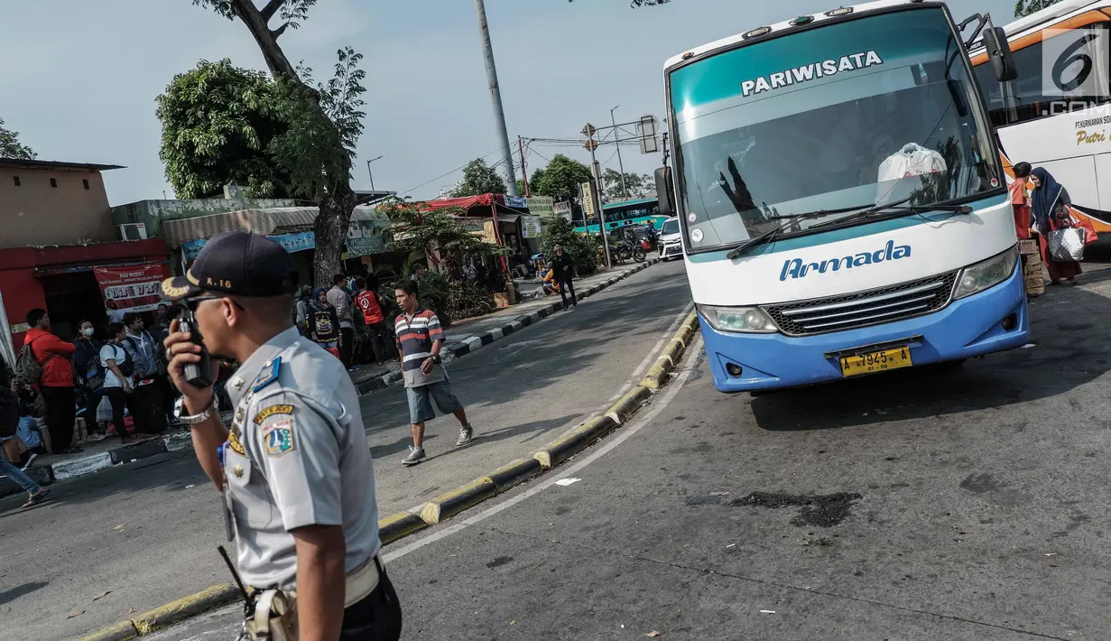Petugas mengatur lalulintas di Terminal Kalideres, Jakarta, Kamis (30/5/2019). Menurut Badan Pengelola Transportasi Jabodetabek (BPTJ) puncak arus mudik di Terminal Kalideres diprediksi akhir pekan ini, mulai dari Jumat hingga Sabtu. (Liputan6.com/Faizal Fanani)