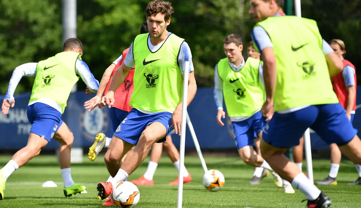 Bek Chelsea, Marcos Alonso (tengah) menggiring bola saat mengikuti latihan tim di Chelsea Training Ground, di Cobham, Surrey (22/5/2019). Chelsea akan bertanding melawan Arsenal pada babak Final Liga Europa pada 29  Mei di Baki Olimpiya Stadionu. (AFP Photo/Ben Stansall)