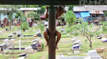 Seorang anak bermain di sekitar TPU Karet Bivak, Jakarta, Jumat (13/1). Semakin berkurangnya lahan hijau menyebabkan anak-anak di Ibukota terpaksa bermain di tempat yang tidak semestinya. (Liputan6.com/Immanuel Antonius)