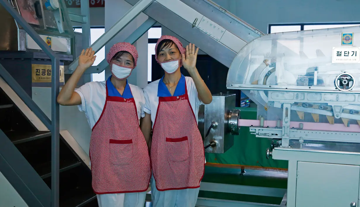 Pekerja Korea Utara melambaikan tangan ke arah jurnalis yang mengunjungi Pabrik Kosmetika Pyongyang di Pyongyang, 8 September 2018. Pabrik Kosmetik Pyongyang adalah salah satu produsen utama barang-barang kosmetik di Korea Utara. (AP Photo/Ng Han Guan)