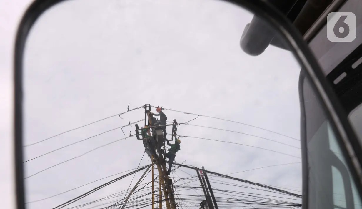 Petugas melakukan maintenence trapo listrik di Kota Tangerang, Banten, Jumat (26/11/2021). Pemerintah mau mendorong investasi baru terutama industri supaya konsumsi listrik bisa mengimbangi. (Liputan6. com/Angga Yuniar)