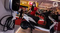 Model berpose dekat sepeda motor listrik pada pembukaan Indonesia Motorcycle Show (IMOS) 2022 di stan Yamaha, Jakarta Convention Center (JCC), Jakarta, Rabu (2/11/2022). Pameran ini diselenggarakan oleh Asosiasi Industri Sepedamotor Indonesia (AISI). (Liputan6.com/Johan Tallo)