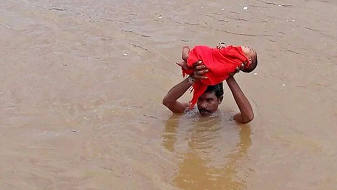Perjuangan Ayah Pegang Bayi yang Sakit Sambil Mengarungi Banjir