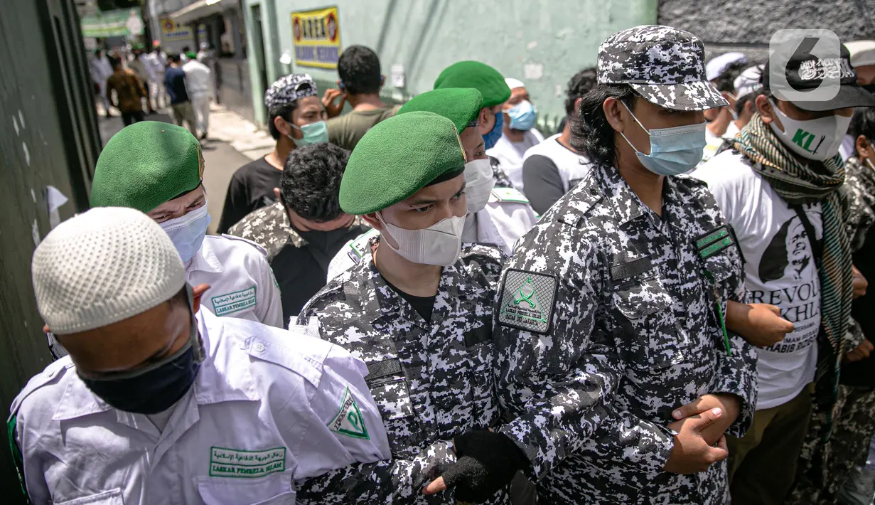 Anggota FPI membuat barikade saat mengadang anggota Polda Metro Jaya yang ingin memberi surat pemanggilan kepada Rizieq Shihab di kediamannya di Petamburan, Jakarta, Rabu (2/12/2020). Polisi kembali memanggil Rizieq Shihab terkait acara Maulid Nabi dan resepsi putrinya. (Liputan6.com/Faizal Fanani)