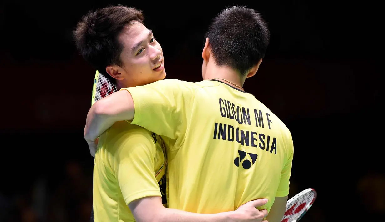 Pasangan ganda putra Indonesia, Kevin Sanjaja Sukamuljo dan Marcus Feraidi Gideon berpelukan usai mengalahkan wakil tuan rumah, Takuto Inoue/Yuki Kaneko pada Japan Open 2017 di Tokyo, Jepang, (24/9). (AFP Photo/Toru Yamanaka)