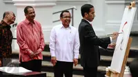 Presiden Jokowi menggores kuas di kanvas putih sebagai tanda dibukanya pameran seni rupa koleksi Istana Kepresidenan RI bertajuk ‘17:71 Goresan Perjuangan’ di Galeri Nasional, Jakarta, Senin (1/8). (Liputan6.com/Faizal Fanani)