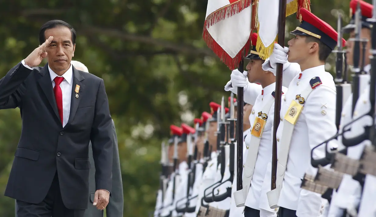 Presiden Jokowi memberikan hormat saat menginspeksi barisan tentara dalam seremonial penyambutan di Istana Kepresidenan Singapura,Selasa, (28/7/2015). Jokowi akan berada di Singapura selama dua hari. (REUTERS/Edgar Su)
