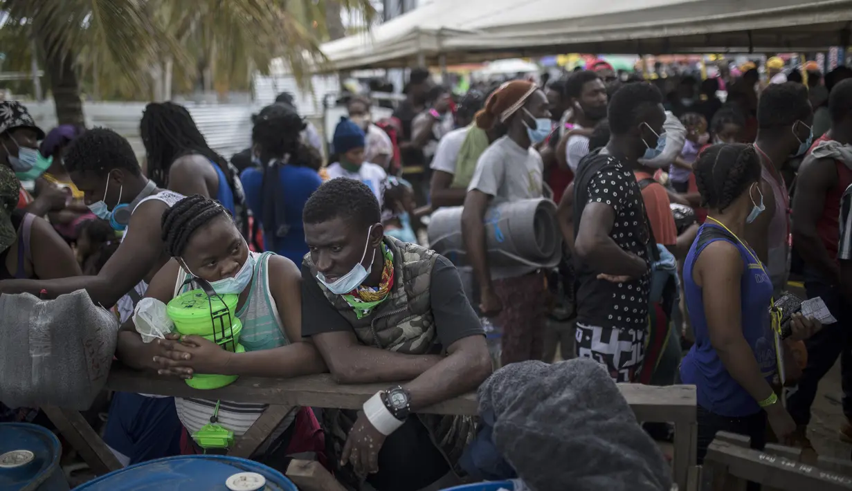 Para migran Haiti berkumpul sebelum menaiki perahu menuju Capurgana dekat perbatasan dengan Panama, di Necocli, Kolombia, Rabu (28/7/2021). Ribuan migran telah berkumpul di Necocli saat mereka bergerak ke utara menuju Panama dalam perjalanan mereka ke perbatasan AS. (AP Photo/Ivan Valencia)