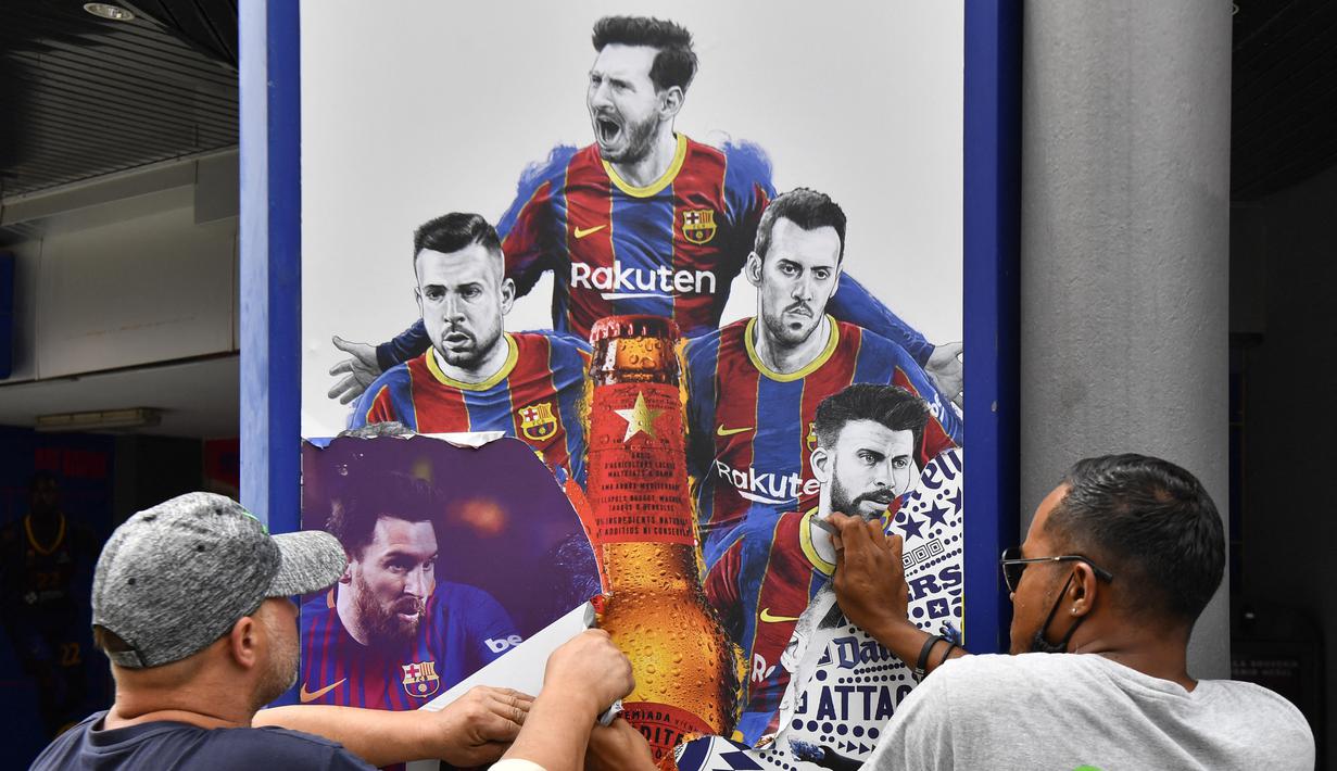 Pekerja melepas poster-poster yang menampilkan pemain depan Barcelona Lionel Messi di stadion Camp Nou di Barcelona (10/8/2021). Prancis menunggu dengan tidak sabar Lionel Messi dengan para pendukung berkumpul di luar lapangan Paris Saint-Germain. (AFP/ Pau Barrena)